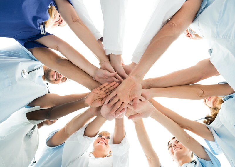A group of people putting their hands in the middle